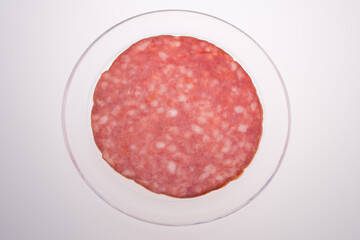 Thin salami slice directly above ,in a transparent  dish