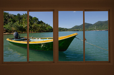 Green boat in the sea in window view