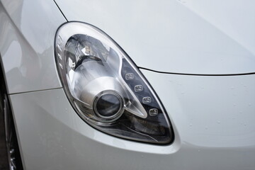 Car's exterior detail,new headlight on a white silver car