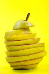 Cut into slices of ripe pear on a yellow background