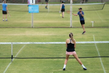 Amateur playing tennis at a tournament and match on grass in Melbourne, Australia 