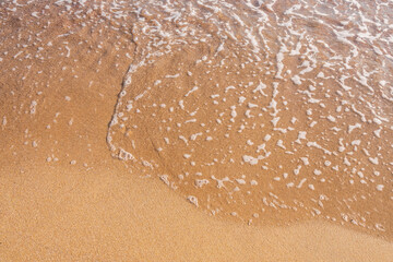 Soft wave of the sea on the sandy beach.