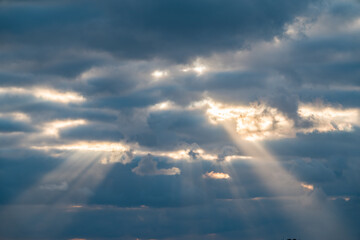 Fototapeta na wymiar Dramatic sky with sunbeams through the clouds