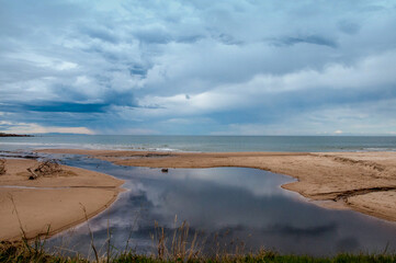river passing in the sand and flowing into the sea in uruguay