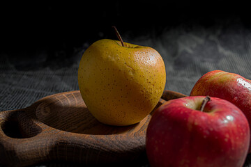 Ripe yellow and red apples on a wooden board. Close-up