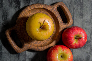 Ripe yellow and red apples on a wooden board. Close-up