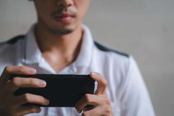 young man working on a horizontal phone with two hands.