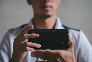 young man holding a phone horizontally to take pictures.