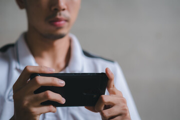 young man working on a horizontal phone with two hands.