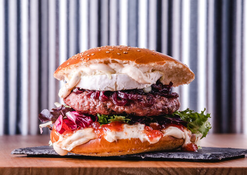 Big burger with goat cheese and tomato jam ready to eat. Fastfood concept