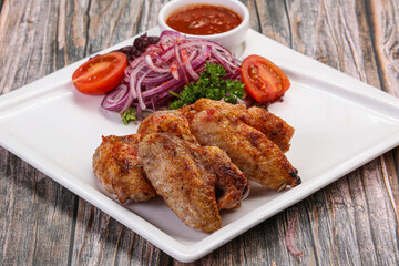Grilled chicken wings served onion