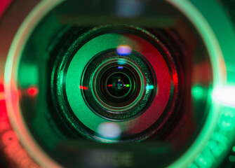 Video camera lens closeup lit by red and green color light