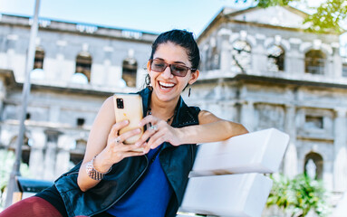 An attractive girl sitting on the cell phone smiling, Girl sitting on a bench texting on her cell...