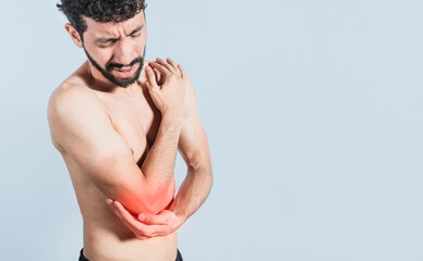 Fototapeta premium Person with elbow pain, concept of a man with elbow pain from rheumatism, shirtless man massaging sore elbow, man with elbow cramp