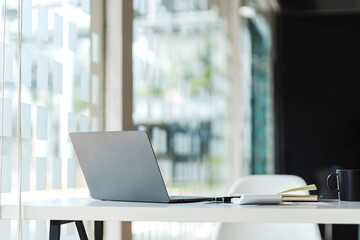 Close up of creative designer table with open laptop turned away. Mock up