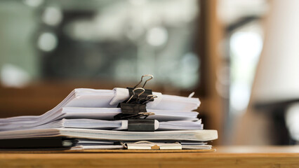 Paper stack on the desk related to business functions.