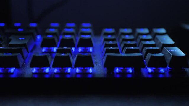Cinematic dolly shot of a colroful LED keyboard in a dark room