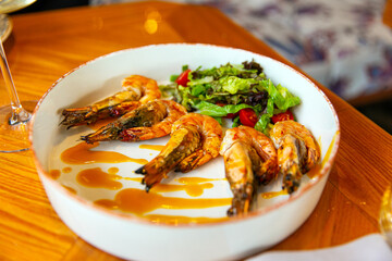 Appetizing fried shrimp in mustard sauce with fresh vegetables