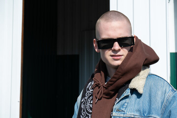 Obraz premium Young man with the sunglasses on the street at the sunny day
