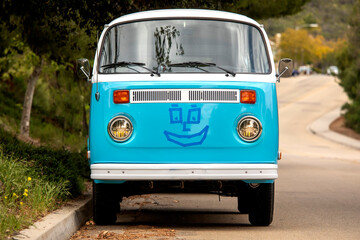 Vintage powder blue bus with a smiley face on the front
