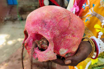 The picture of a human skull held in a woman Tantrik or black magician's hand- who performs various...