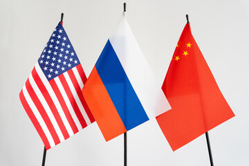 State flags of America, Russia, China on white background. Russian flag in centre. Conflict concept