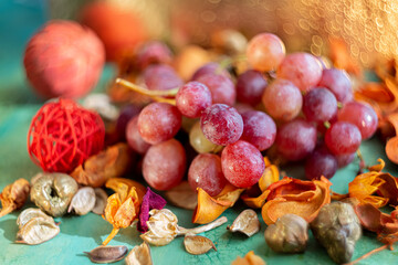 Pink sweet grapes on a green table and blurred beautiful background with yellow bokeh. Fruits. Shallow depth of field. Food.The artistic intend and the filters. Film style old lens. Airy atmosphere.