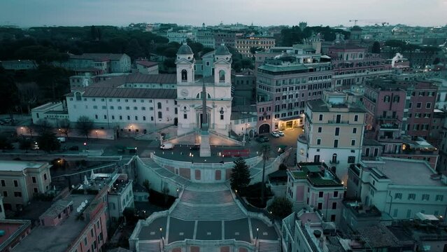 Aerial view over the Spanish steps, towards the Trinita dei Monti church, evening in Rome, Italy - approaching, tilt, drone shot