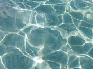 Crystal clear blue water of the Mediterranean Sea on the beach of Fig Tree Bay, white sand is visible at the bottom. Water background.