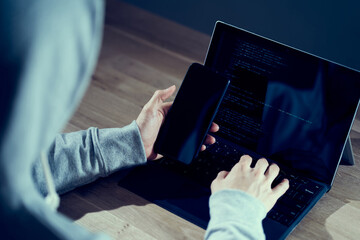 スマホでの動作チェックをする男性ハッカー	