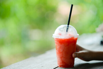 Teenager boy drinking fruit juice in the park camping summer time
