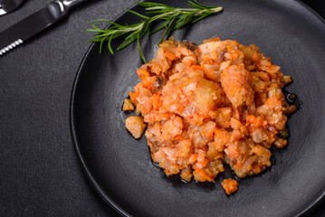 A delicious dish of hake fish in chunks in tomato sauce with spices and herbs