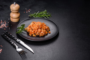 A delicious dish of hake fish in chunks in tomato sauce with spices and herbs