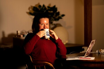 Young beautiful woman relaxing making making hot tea and coffee with a tea bag, in the kitchen of a home in melbourne, Australia.