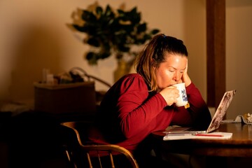 Young beautiful woman relaxing making making hot tea and coffee with a tea bag, in the kitchen of a home in melbourne, Australia.