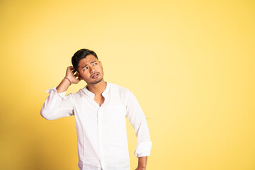 asian young man confused with hand scratching head hair on isolated background
