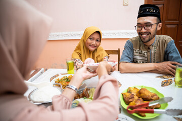 beautiful asian family having dinner at home. asian muslim eating iftar at their house