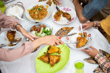 close up of a hand preparing food on dining table. traditional indonesian food