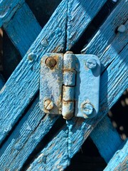 old wooden door with a hinge painted in blue color