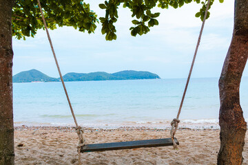 landscape of swing hanging with tree and beautiful blue sea in Thailand