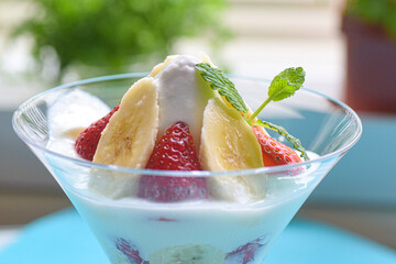 Close up Yogurt Parfait with banana and strawberry on the Table