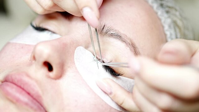 Eyelash extension procedure in beauty salon. Lashes close up. Concept spa lash. 
