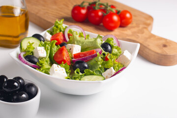 Greek salad with fresh tomatoes, cucumber, olives, feta cheese and red onion. Healthy and diet food concept.
