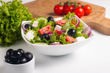 Greek salad with fresh tomatoes, cucumber, olives, feta cheese and red onion. Healthy and diet food concept.