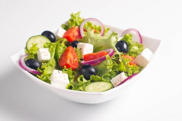 Greek salad with fresh tomatoes, cucumber, olives, feta cheese and red onion. Healthy and diet food concept.