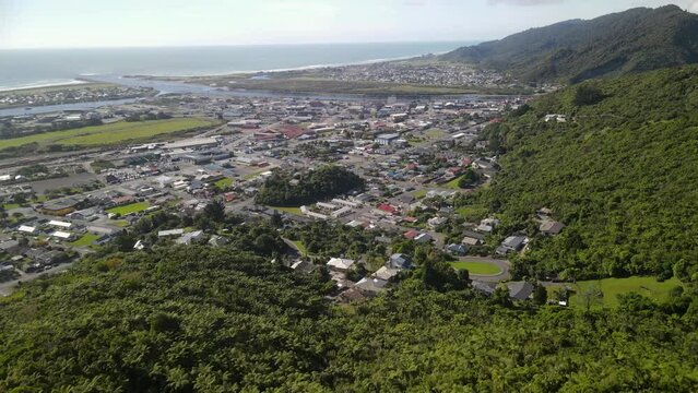 Greymouth, West Coast, New Zealand. Beautiful coastal town, river, forested mountains, ocean. Aerial opening shot