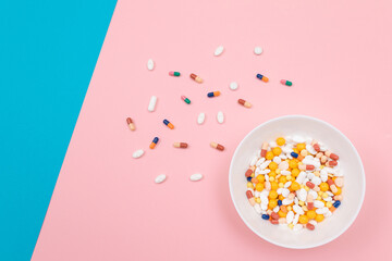 Global Pharmaceutical Industry and Medicinal Products - Colored Pills and Capsules in White Dish on Split Blue and Pink Background