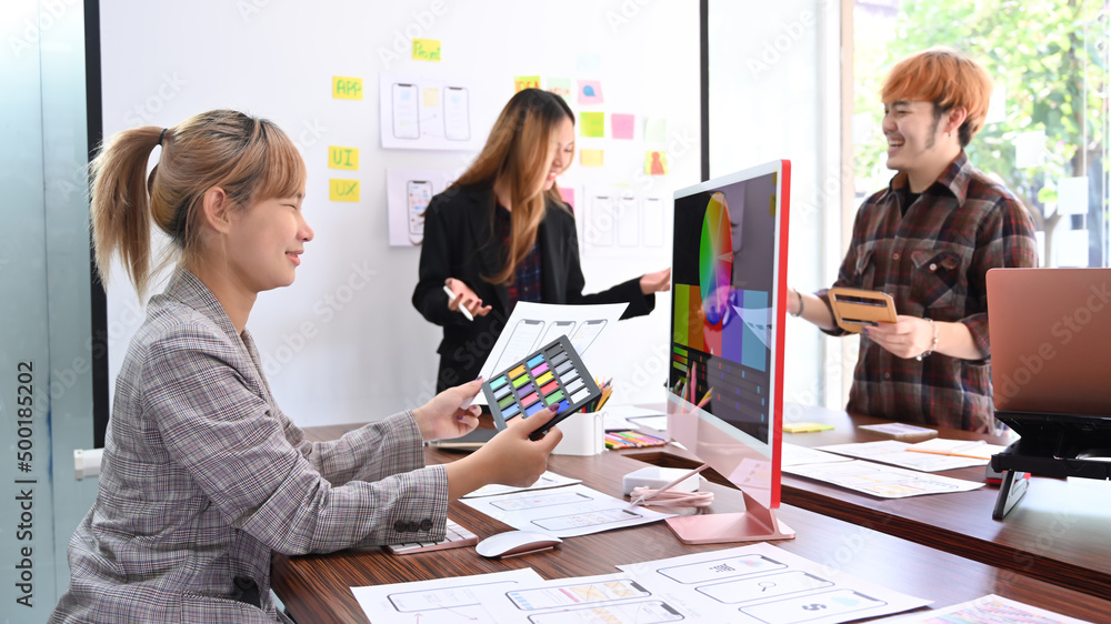 Poster creative team brainstorming, working together on mobile application software design project.