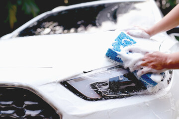 This man is washing the car and cleaning the car.