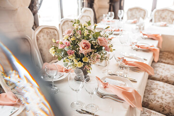 Luxury table setting for dining in a restaurant in pastel colors close up. Wedding party table set for banquet